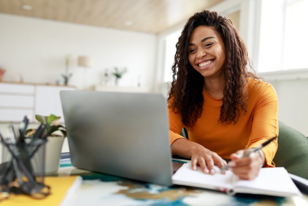 Student on laptop smiling