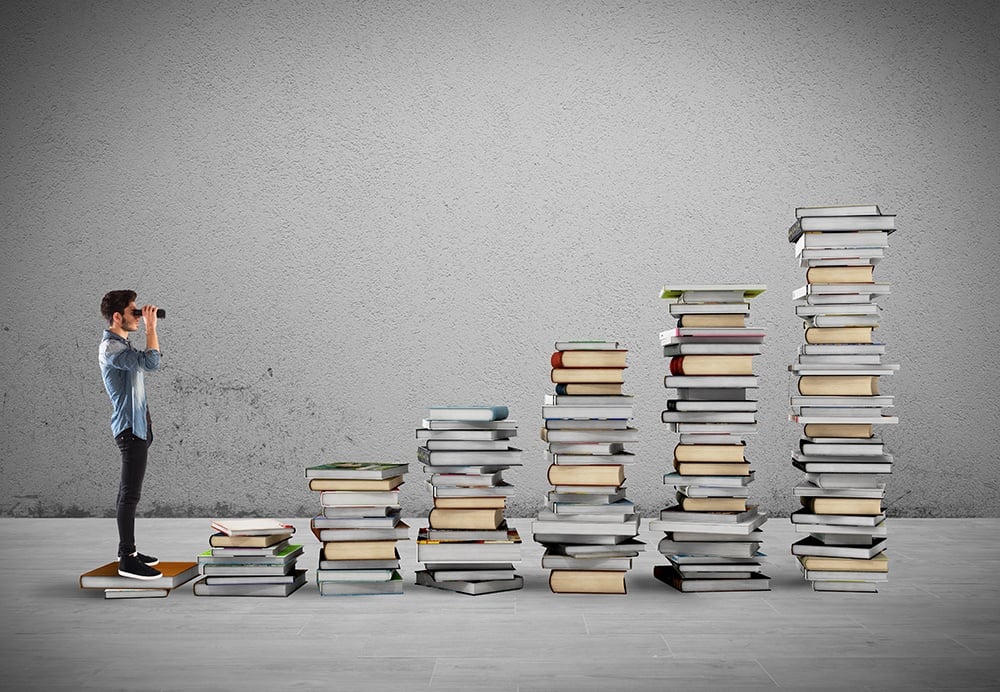 Student-looking-over-book-mountains.jpg